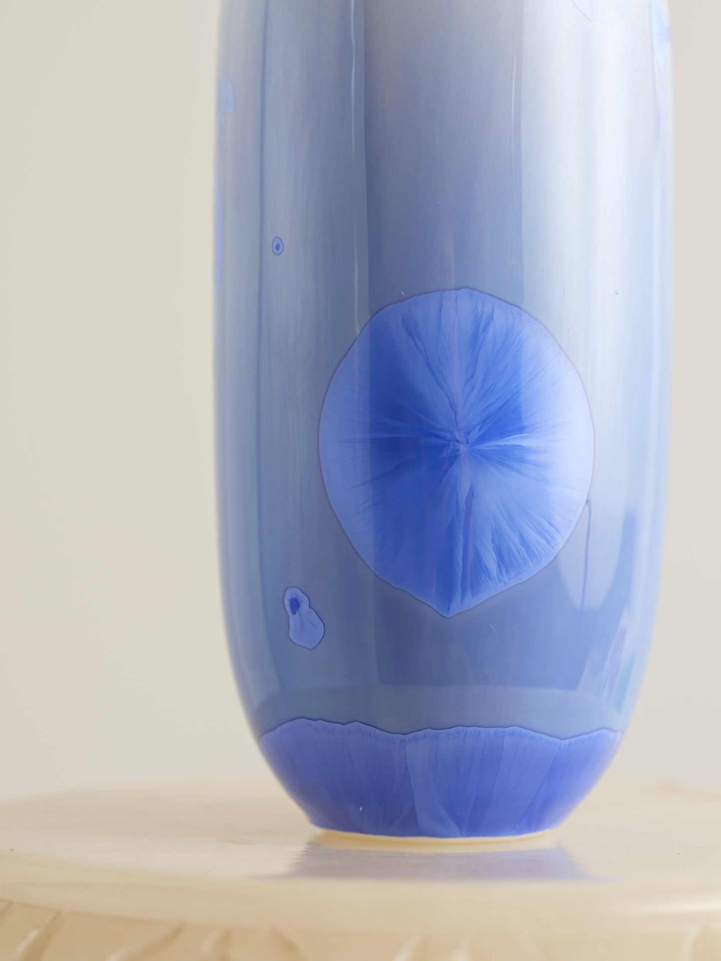 Tall crystalline glaze vase in gradient indigo blue with circular crystal bloom resembling a moon motif.