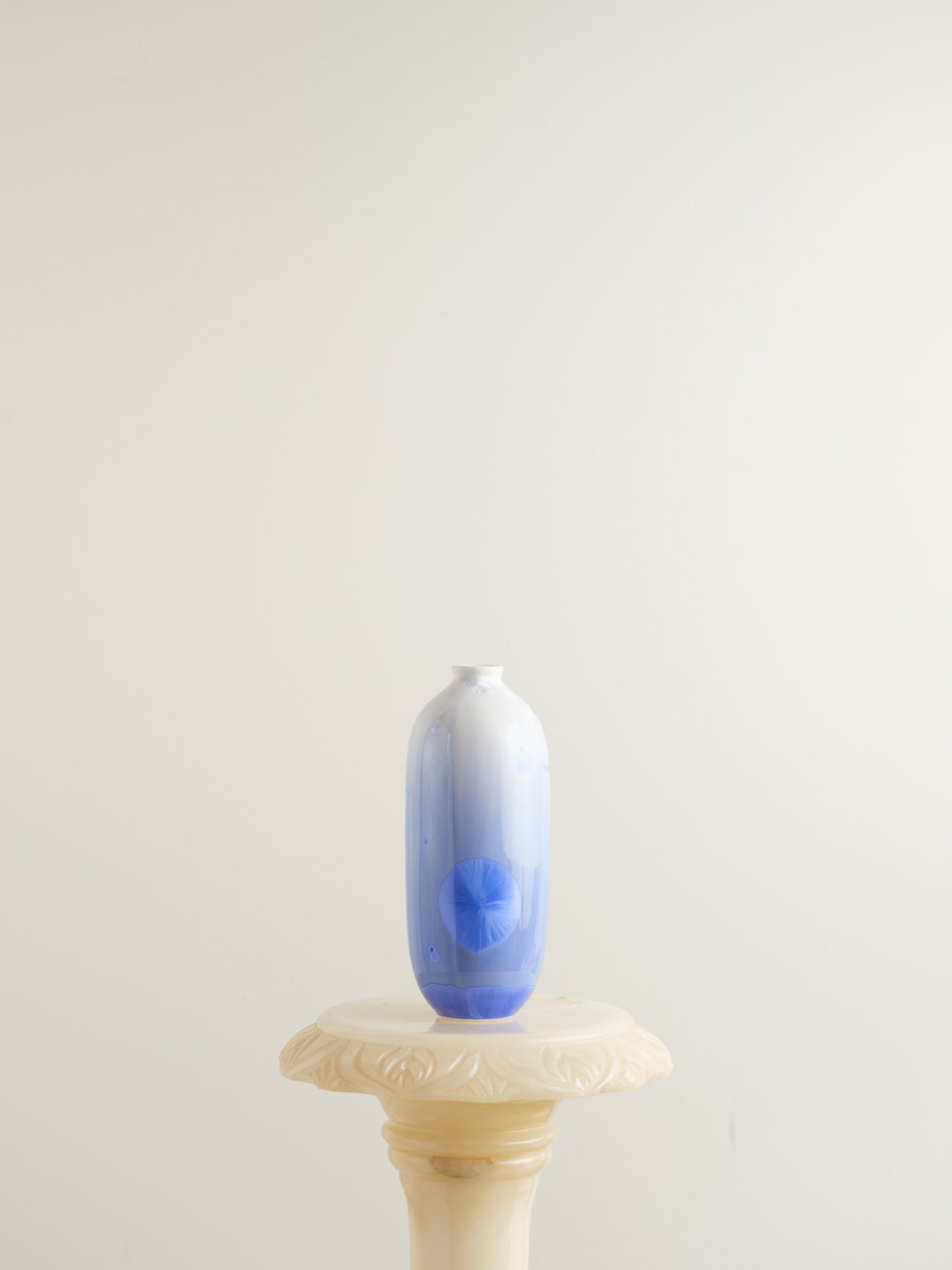 Tall crystalline glaze vase in gradient indigo blue with circular crystal bloom resembling a moon motif.