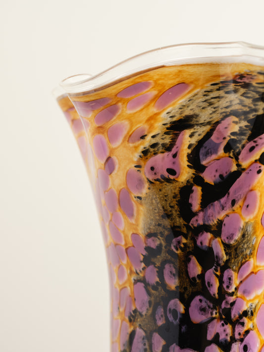 Handblown art glass vase with flowing petal form in shades of lilac, amber, and black.