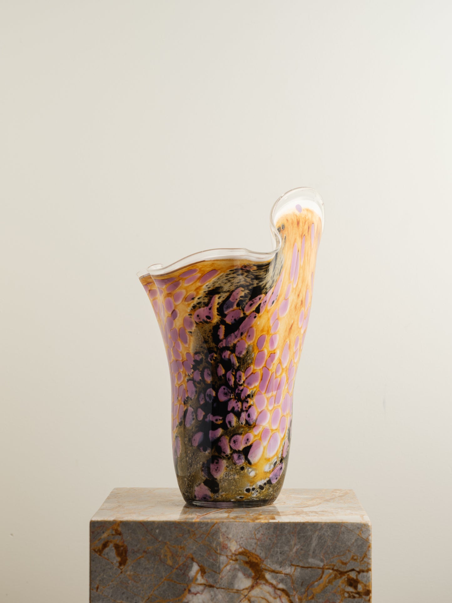 Handblown art glass vase with flowing petal form in shades of lilac, amber, and black.