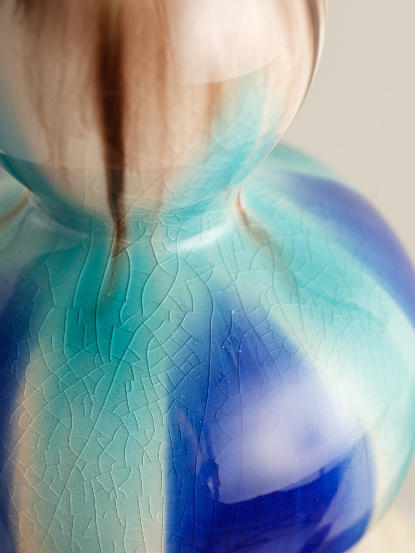 Double-gourd ceramic vase with flowing blue, teal, and beige glaze reminiscent of ocean tides.