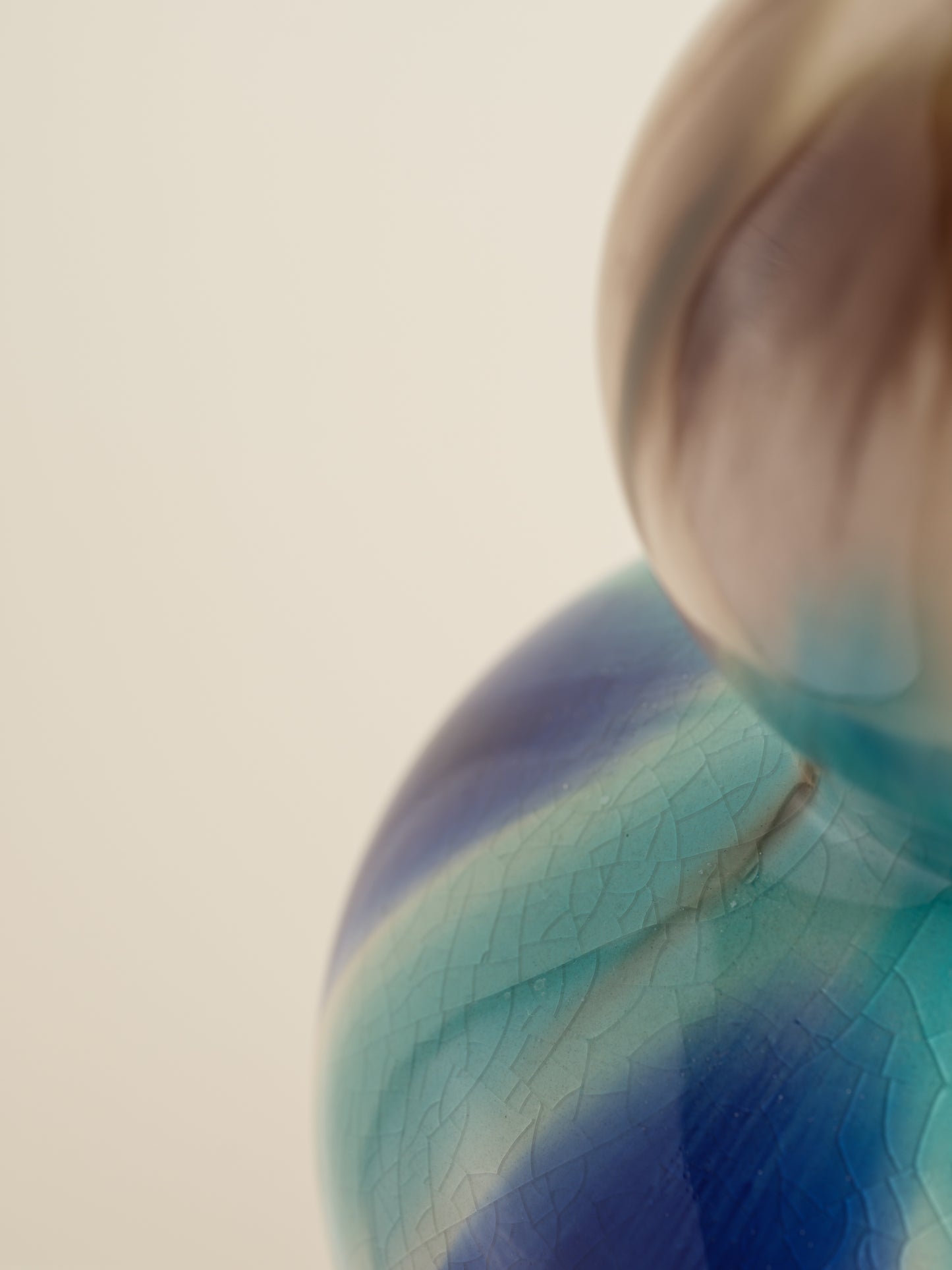 Double-gourd ceramic vase with flowing blue, teal, and beige glaze reminiscent of ocean tides.