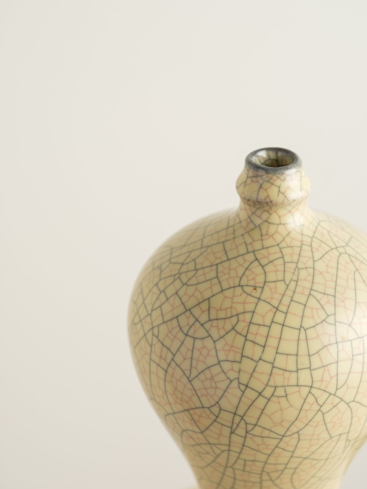 Celadon Crackle Meiping Vase, a traditional ceramic vessel with elegant curves and fine crackle glaze pattern, displayed on a pedestal.