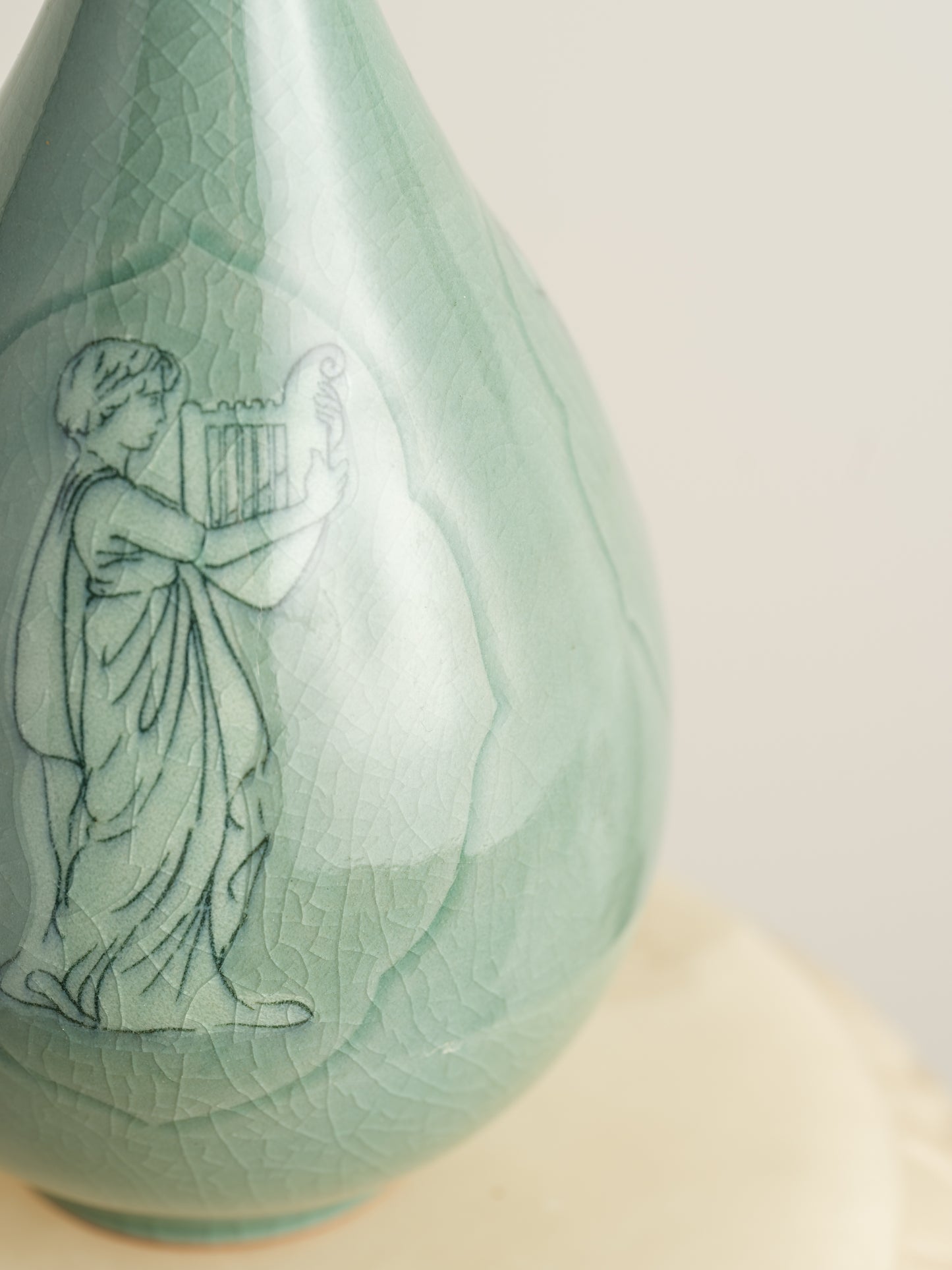 Song Whisper Celadon Vase, a delicate ceramic vessel with a slender flared neck and subtle engraved figure motif on a pale green glaze.