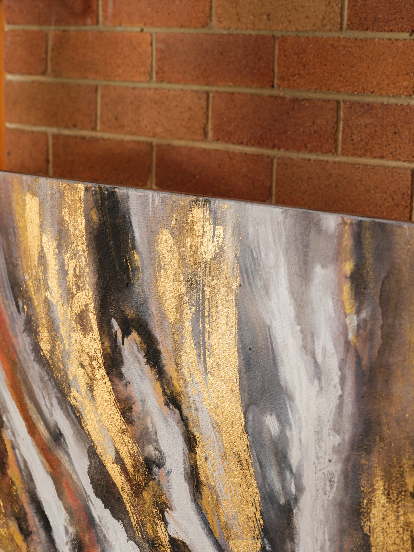 Abstract acrylic painting titled Ember Current, featuring dynamic swirls of gold, black, white, and fiery orange tones.