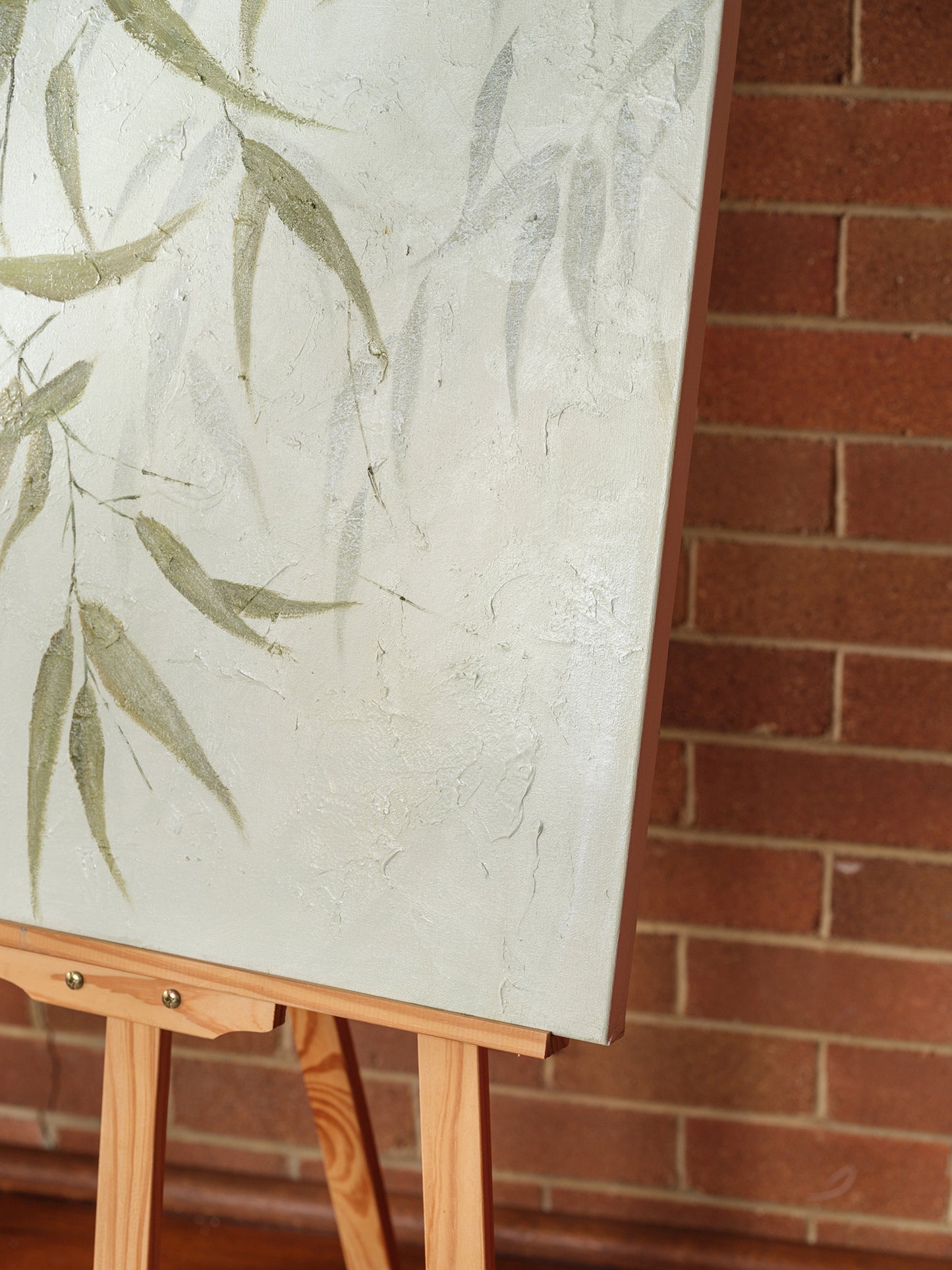 Abstract painting titled Eucalypt Reverie, featuring green eucalyptus leaves with soft brushstrokes on a light canvas background.