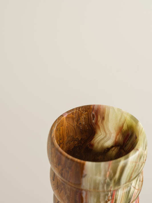 Honey Onyx Ripple Vase with natural striations in warm amber, cream, and green tones, carved in a rippled cylindrical form.
