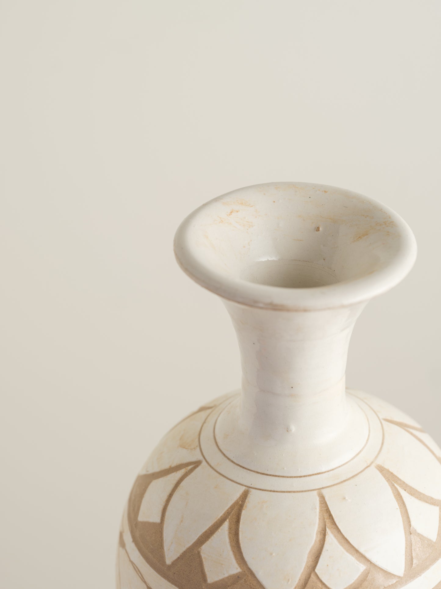 Ivory Blossom Sgraffito Vase, featuring hand-carved floral motifs in contrasting ivory and earthy tones with a traditional rounded body and flared neck.