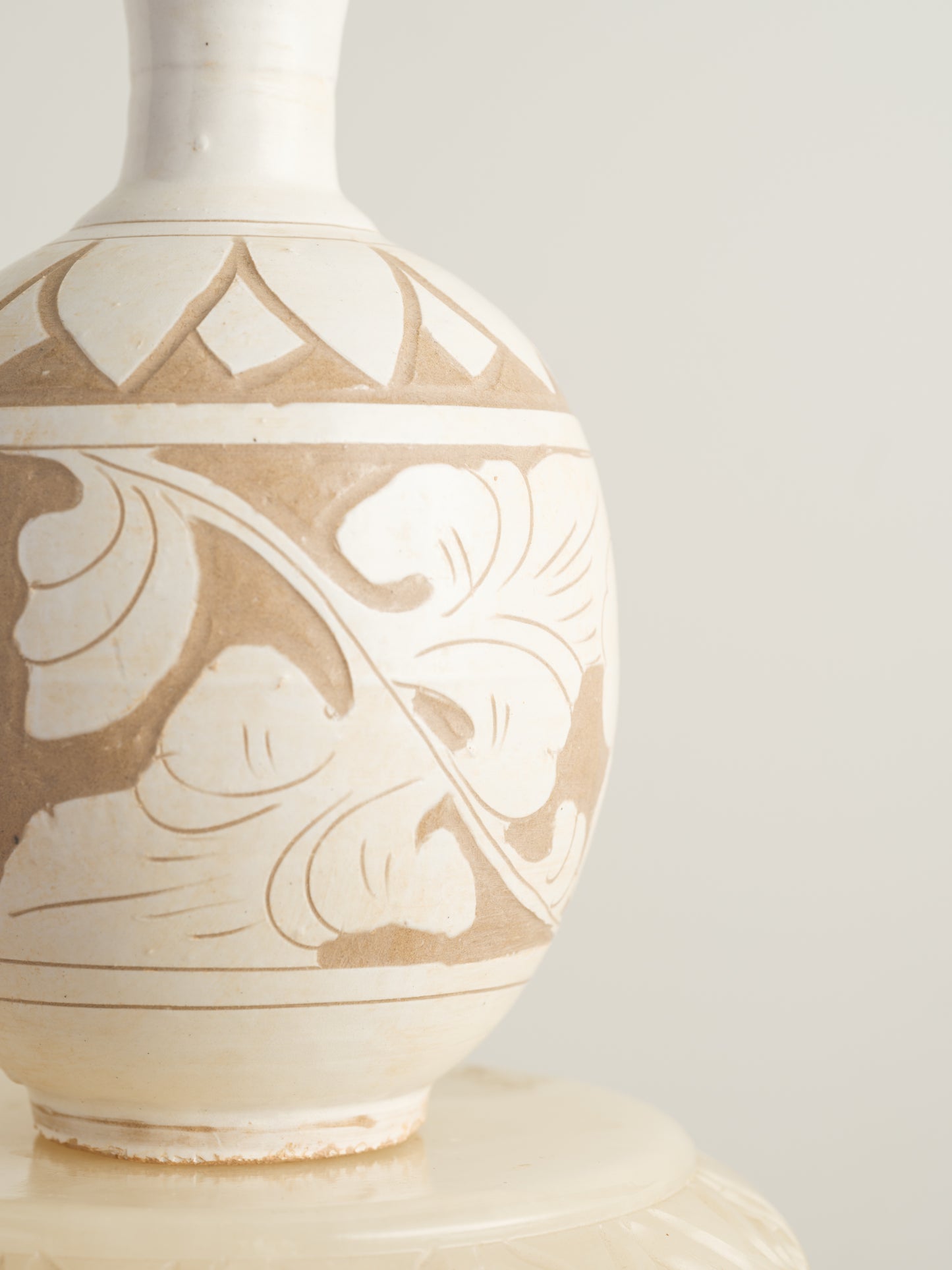 Ivory Blossom Sgraffito Vase, featuring hand-carved floral motifs in contrasting ivory and earthy tones with a traditional rounded body and flared neck.