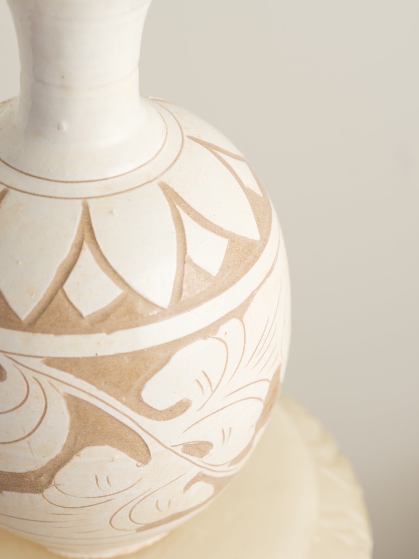 Ivory Blossom Sgraffito Vase, featuring hand-carved floral motifs in contrasting ivory and earthy tones with a traditional rounded body and flared neck.