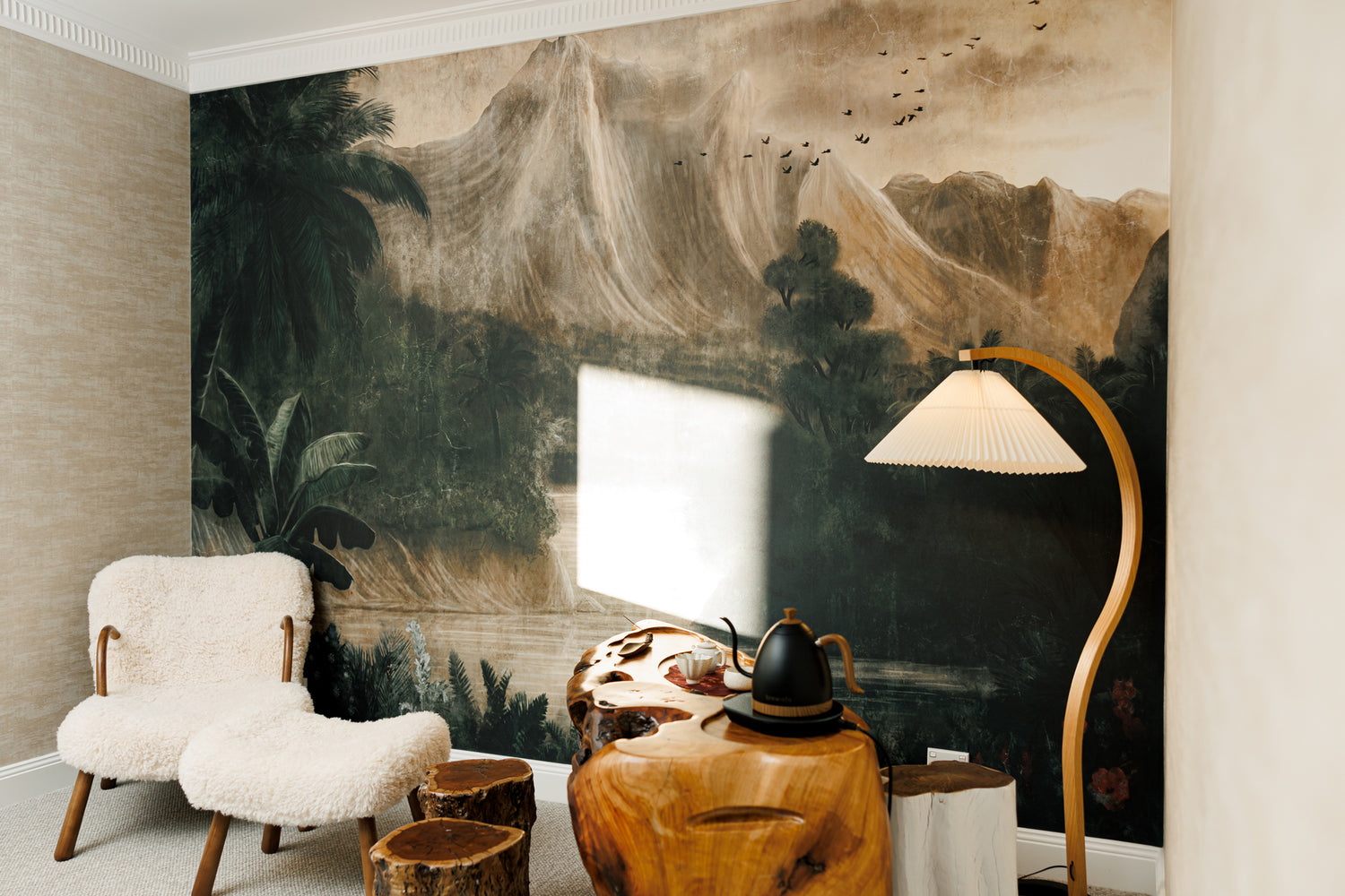 Interior space with mountain landscape wall mural, wooden tea table, sheepskin lounge chair and modern floor lamp