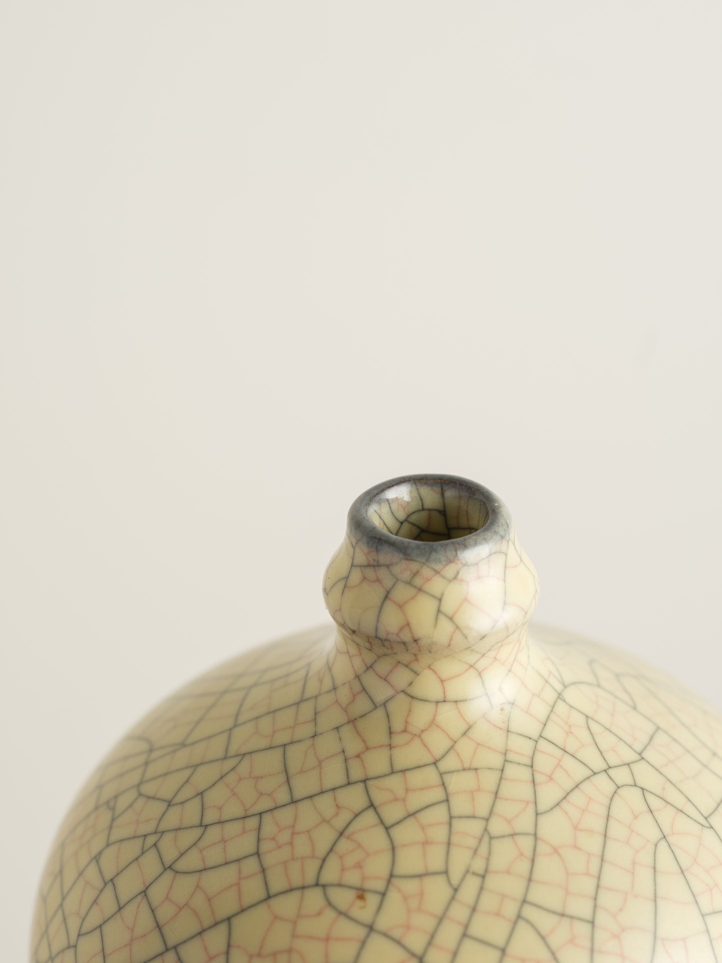 Celadon Crackle Meiping Vase, a traditional ceramic vessel with elegant curves and fine crackle glaze pattern, displayed on a pedestal.