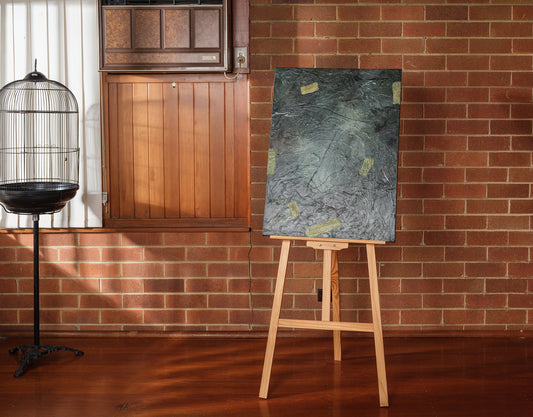 Abstract painting titled Moss & Slate Drift, featuring textured dark green and grey tones with organic golden accents on canvas.