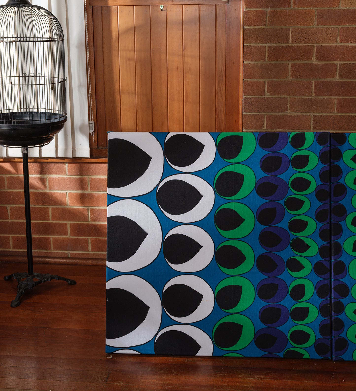 Peacock Rhythm Diptych, a set of two textile artworks with bold circular patterns in blue, green, black, and white, mounted on stretcher frames.