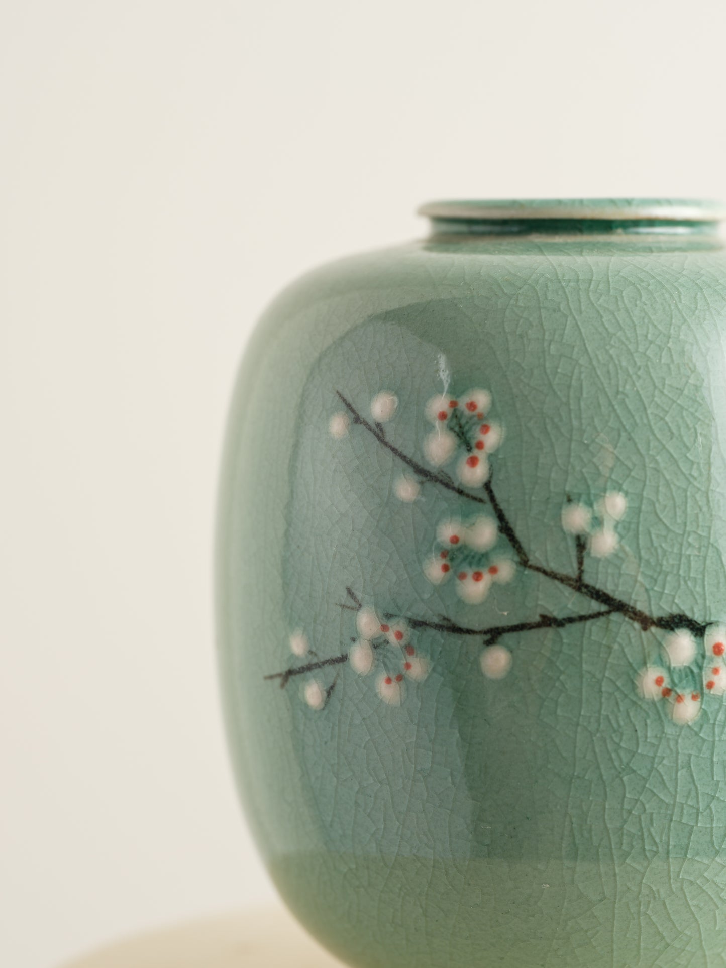 Petite celadon jar with fine crackle glaze, hand-painted plum blossoms and a sparrow motif.