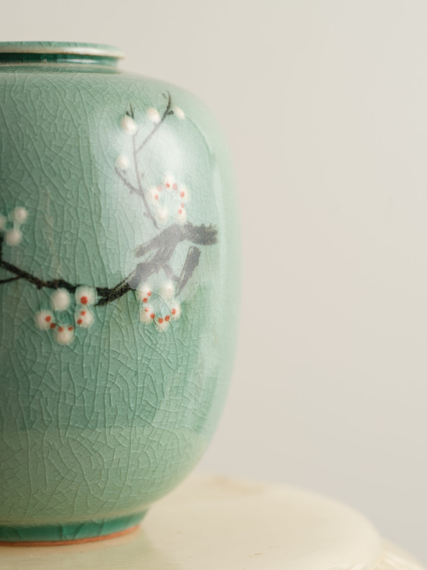 Petite celadon jar with fine crackle glaze, hand-painted plum blossoms and a sparrow motif.
