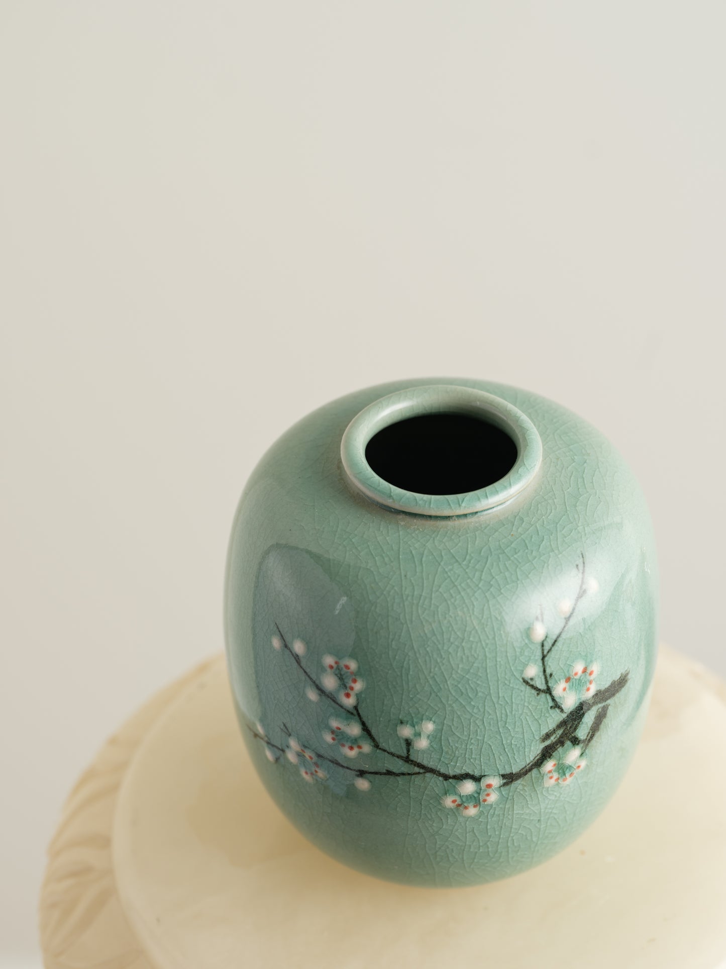 Petite celadon jar with fine crackle glaze, hand-painted plum blossoms and a sparrow motif.