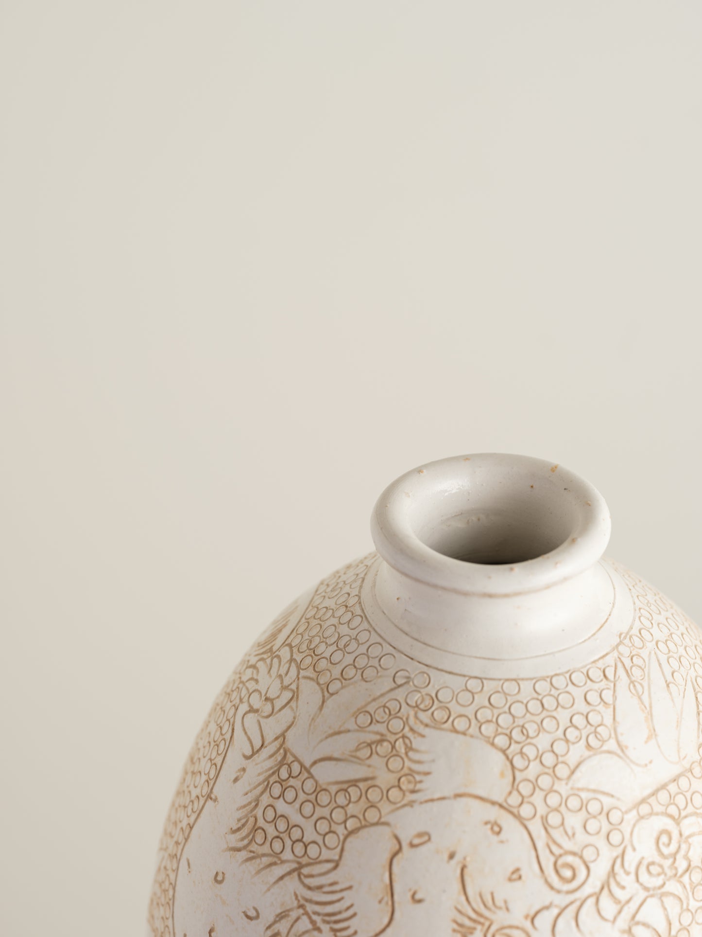 Sgraffito ceramic vase titled Qilin Whisper, featuring an ivory surface etched with a mythological qilin design in soft beige tones.