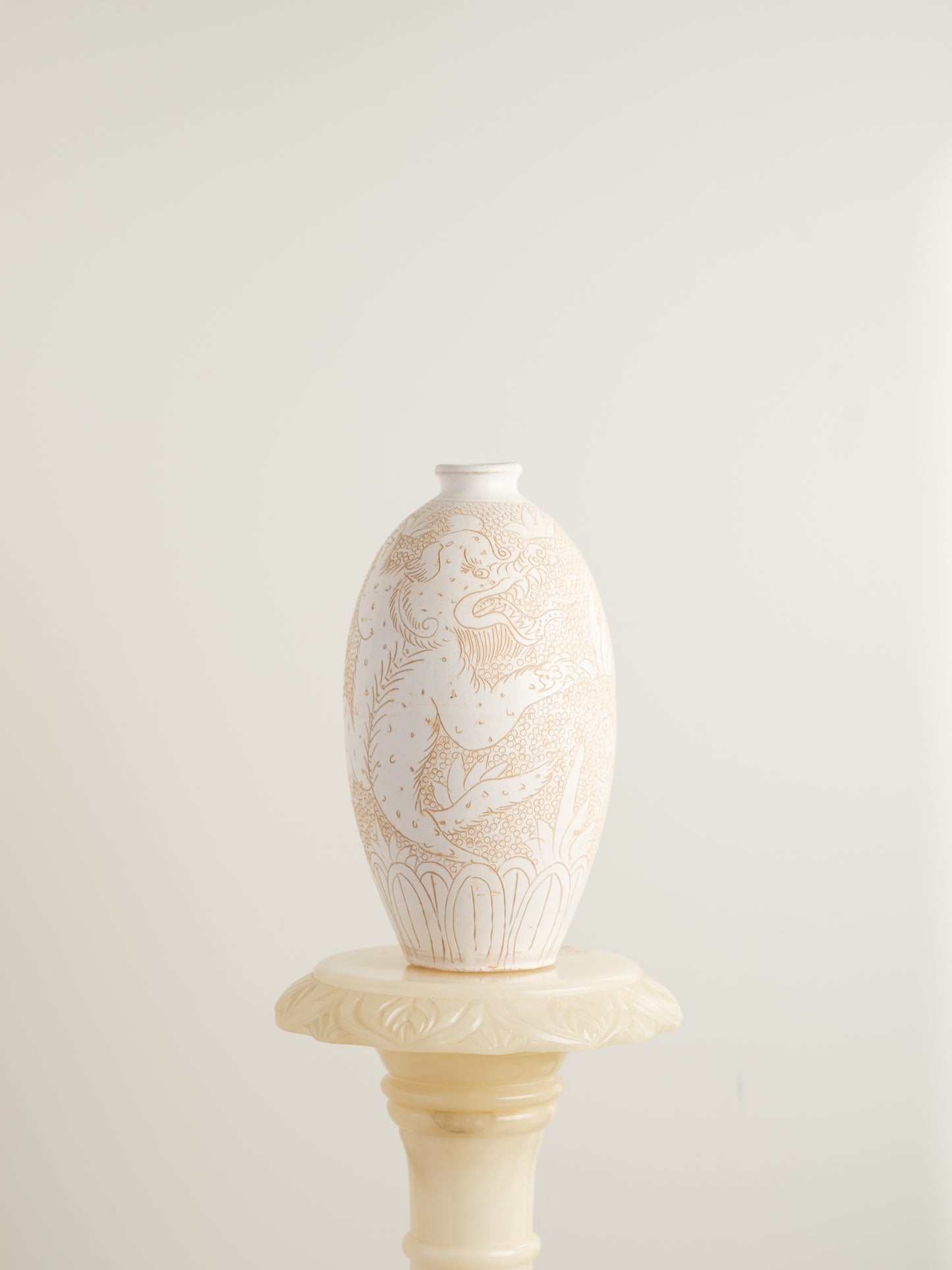 Sgraffito ceramic vase titled Qilin Whisper, featuring an ivory surface etched with a mythological qilin design in soft beige tones.