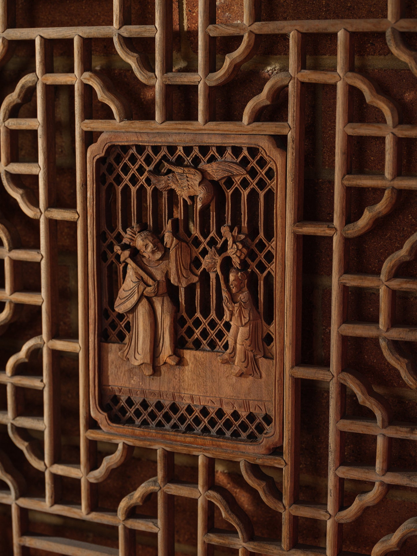 Pair of antique Chinese lattice panels with intricate geometric fretwork and carved scholar scenes in relief at the center.