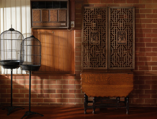 Pair of antique Chinese lattice panels with intricate geometric fretwork and carved scholar scenes in relief at the center.