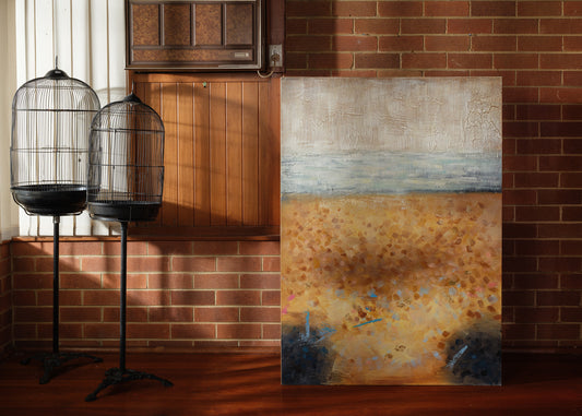 Abstract textured painting titled Shoreline Reverie, depicting layered sandy tones, soft blue horizon, and crackled surface evoking a weathered shoreline.