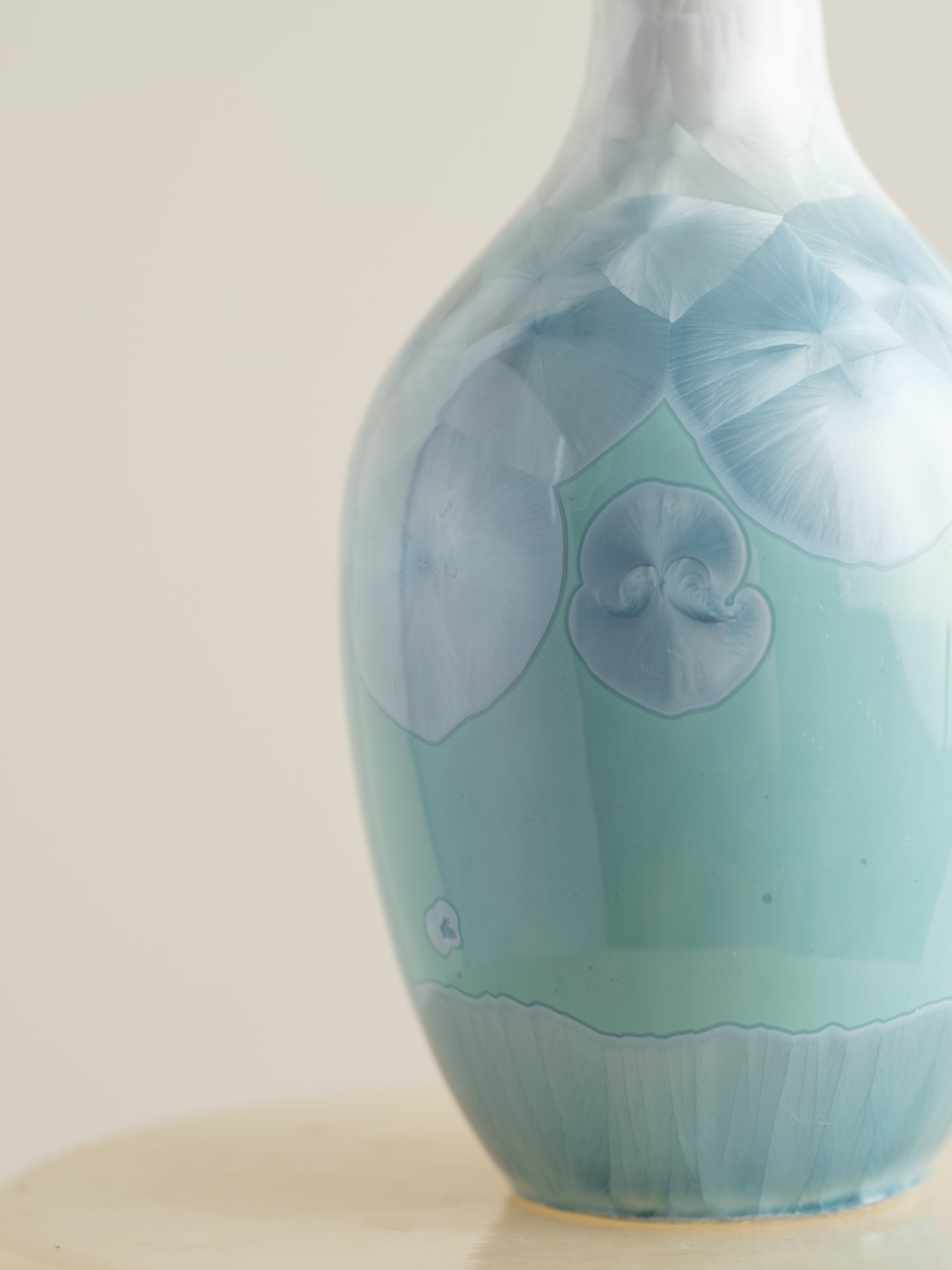 Porcelain vase in gradient white to aqua blue with crystalline bloom patterns on the surface.