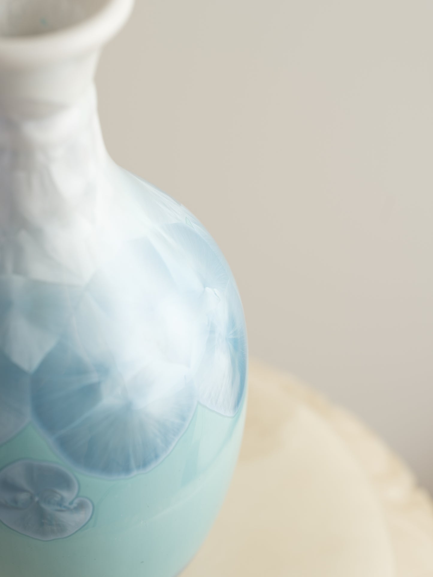 Porcelain vase in gradient white to aqua blue with crystalline bloom patterns on the surface.