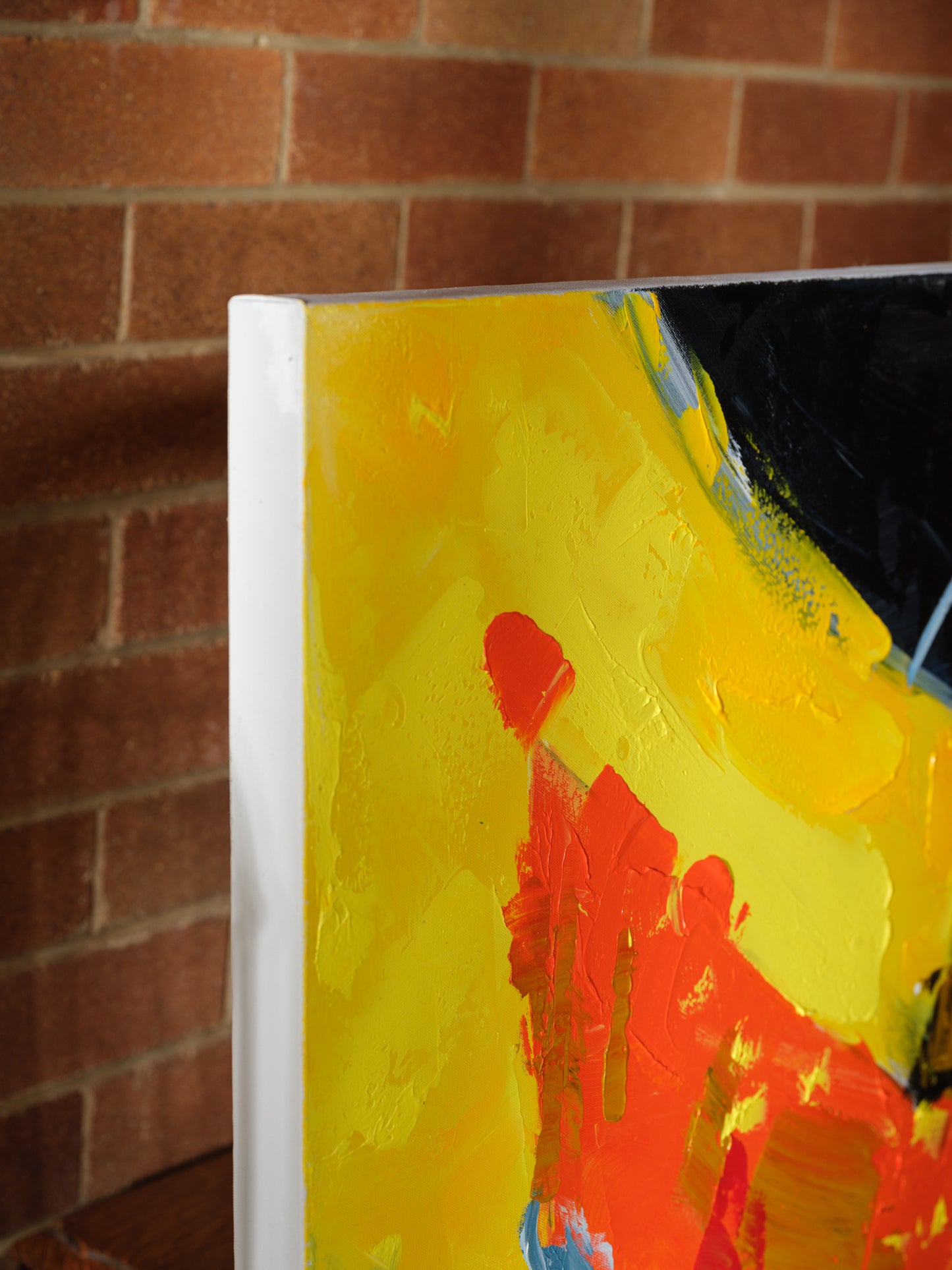 Abstract acrylic painting titled Solar Rift, featuring bold strokes of yellow, red, black, and blue with textured gold accents.