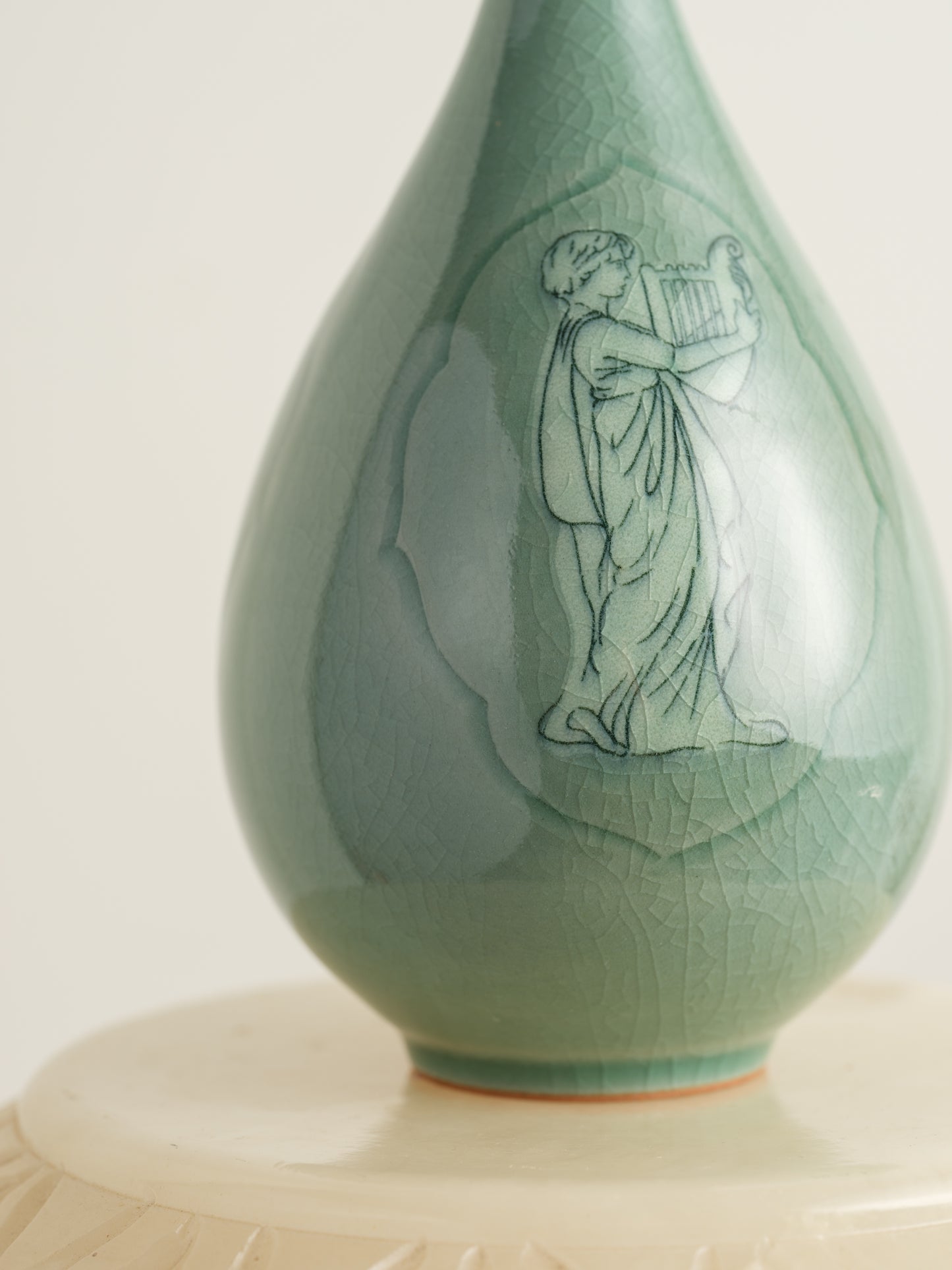 Song Whisper Celadon Vase, a delicate ceramic vessel with a slender flared neck and subtle engraved figure motif on a pale green glaze.