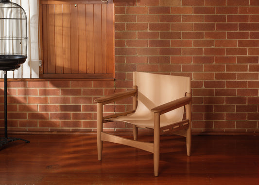 Tanned leather armchair with natural wood frame, modern accent seating