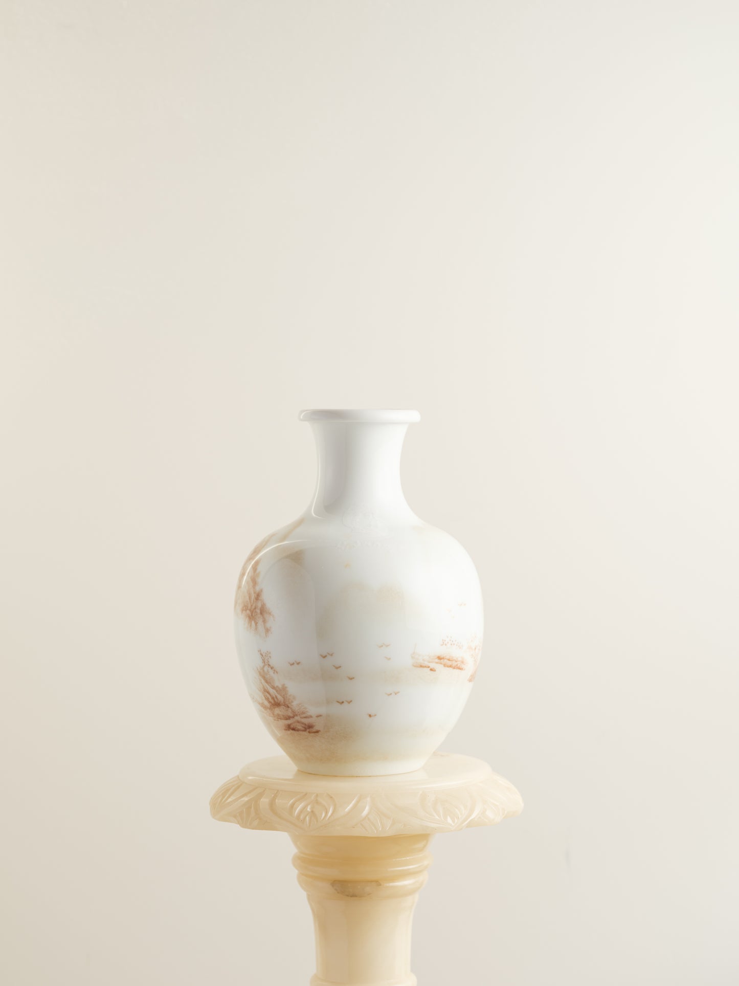 Porcelain vase with tea-wash glaze and hand-painted sepia landscape scene of mountains and flying birds.