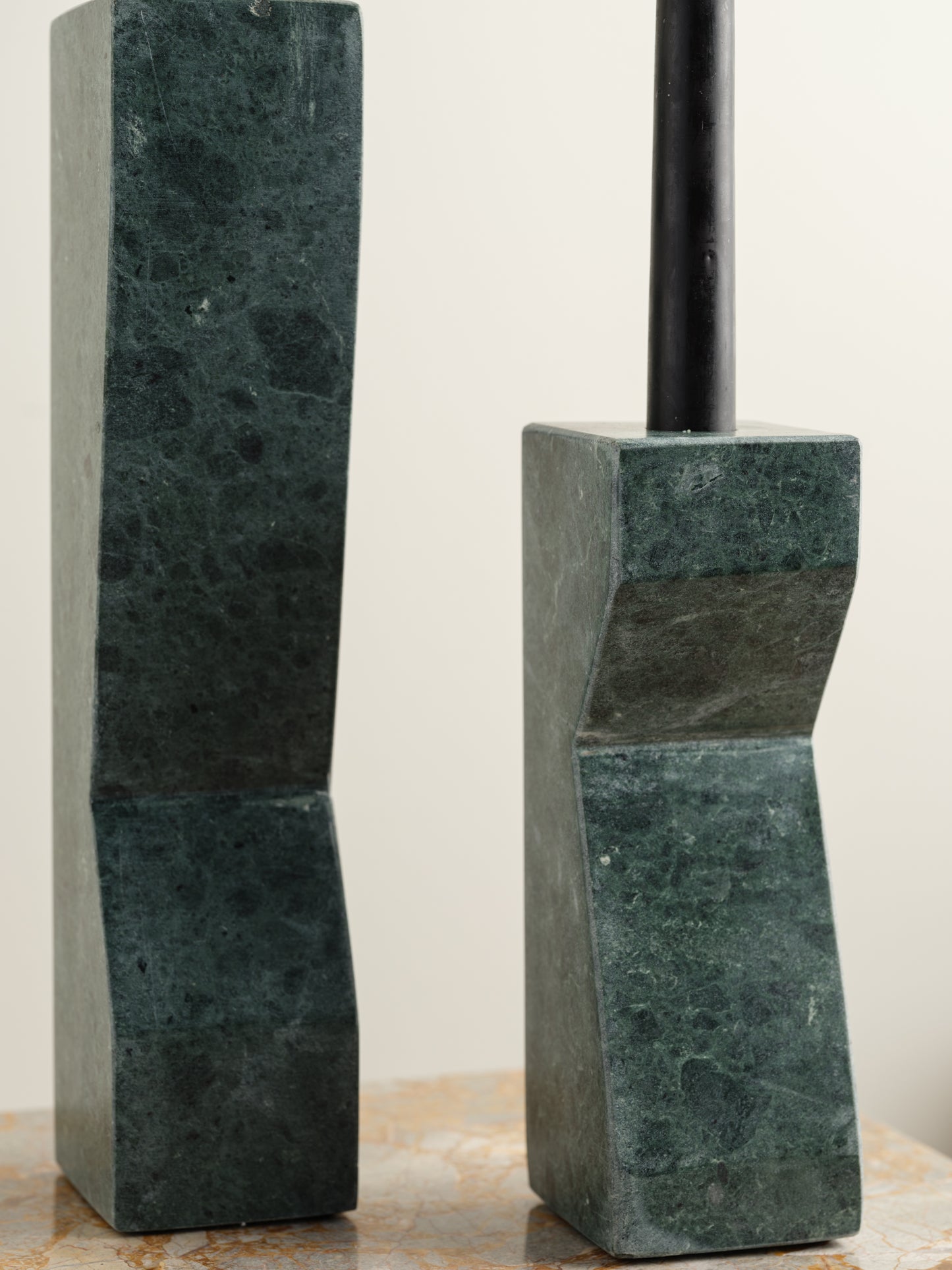 Pair of green marble candle holders with tall rectangular columns and black taper candles.