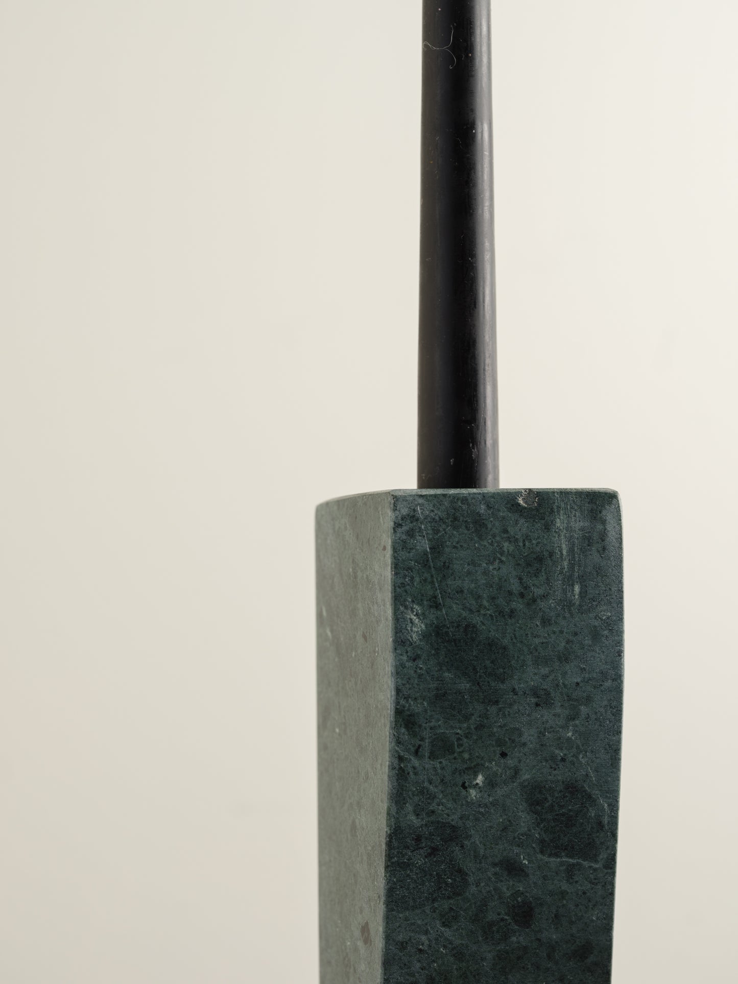 Pair of green marble candle holders with tall rectangular columns and black taper candles.