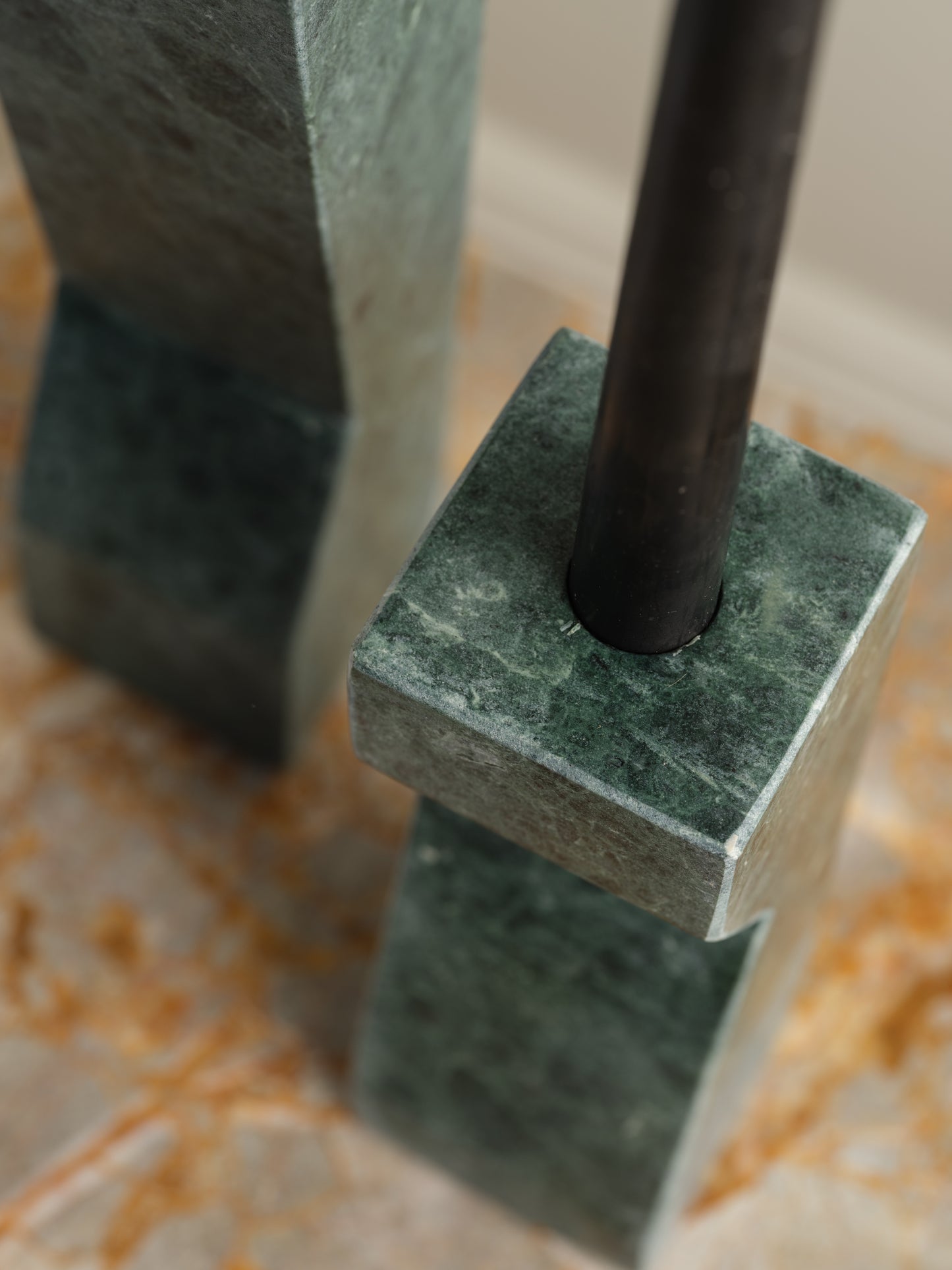 Pair of green marble candle holders with tall rectangular columns and black taper candles.