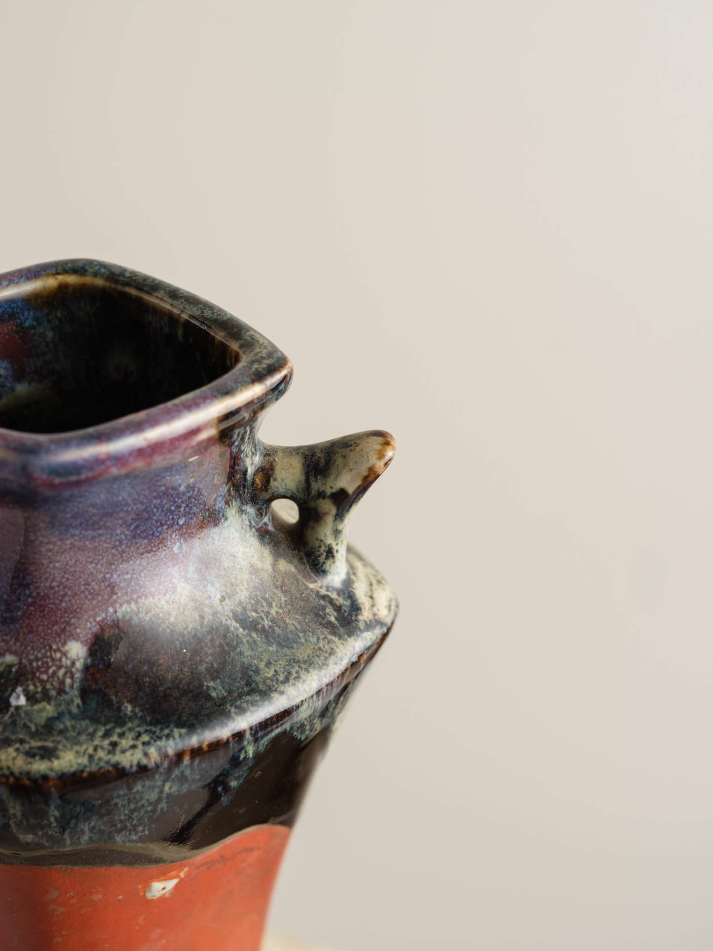 Vermilion Storyteller Relief Vase featuring hand-applied figurative relief on a tall form with dark glaze accents.