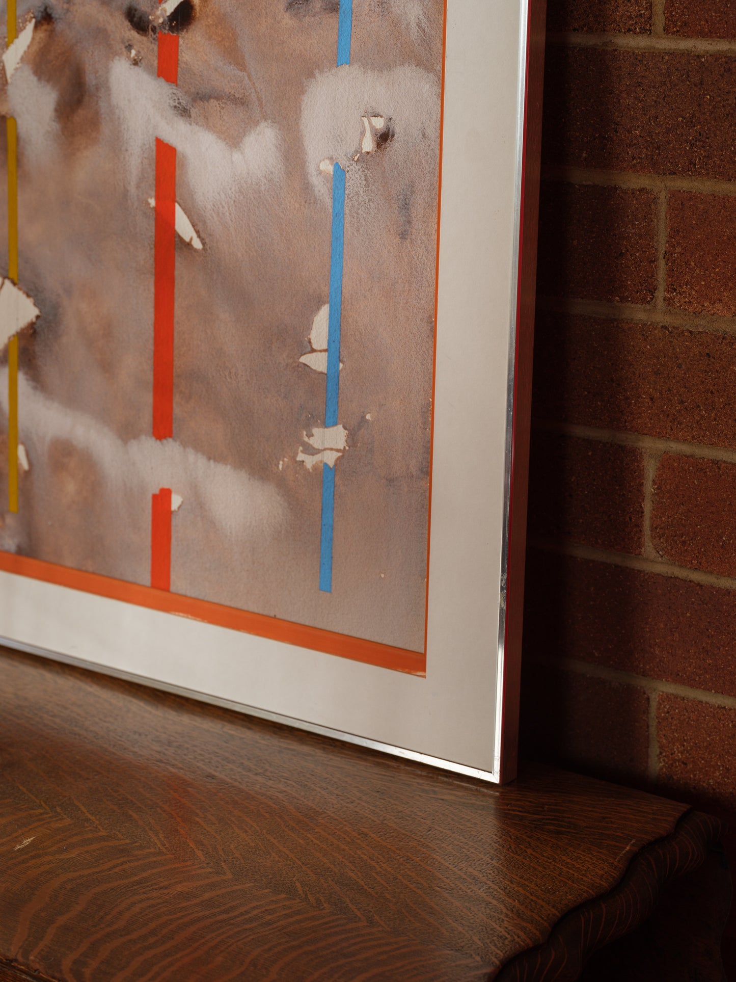 Mixed media artwork titled Weathered Signals, featuring layered earthy textures with vertical signal-like lines in red, yellow, and blue.