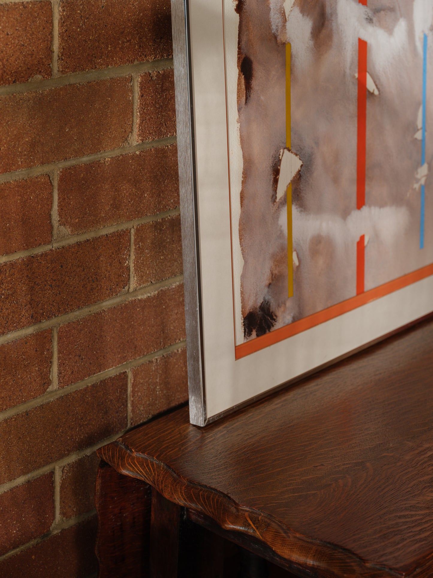 Mixed media artwork titled Weathered Signals, featuring layered earthy textures with vertical signal-like lines in red, yellow, and blue.