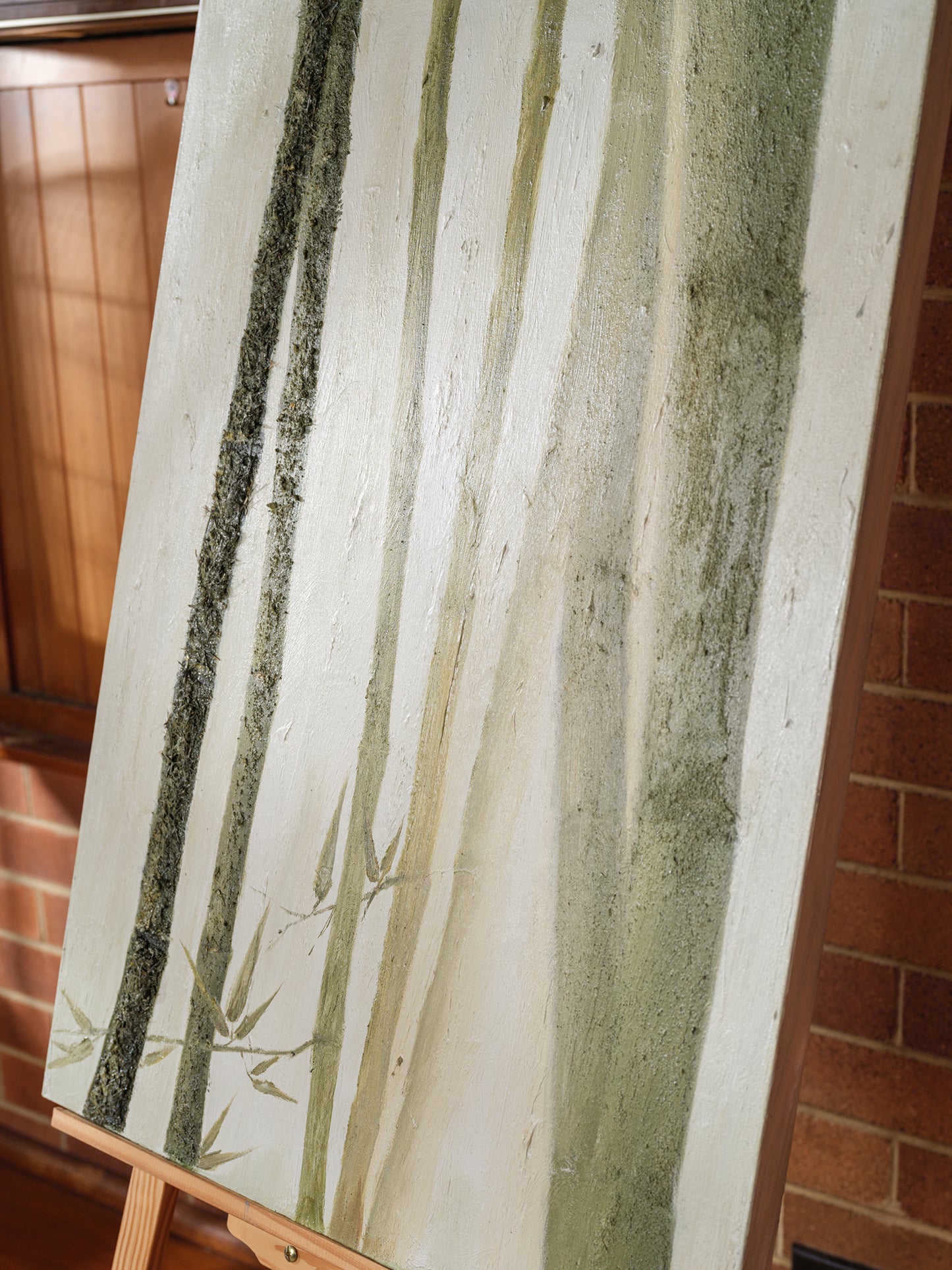 Abstract painting titled Whispering Bamboo, featuring vertical green and white brushstrokes resembling bamboo on canvas.