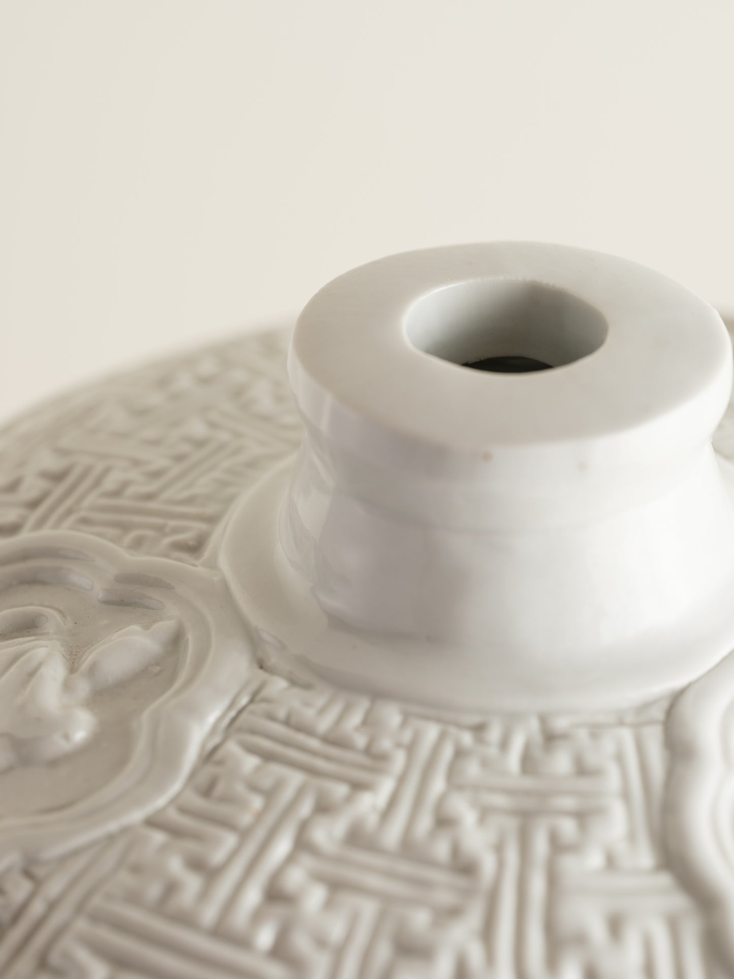White porcelain meiping vase featuring intricate dragon relief motifs and geometric borders.