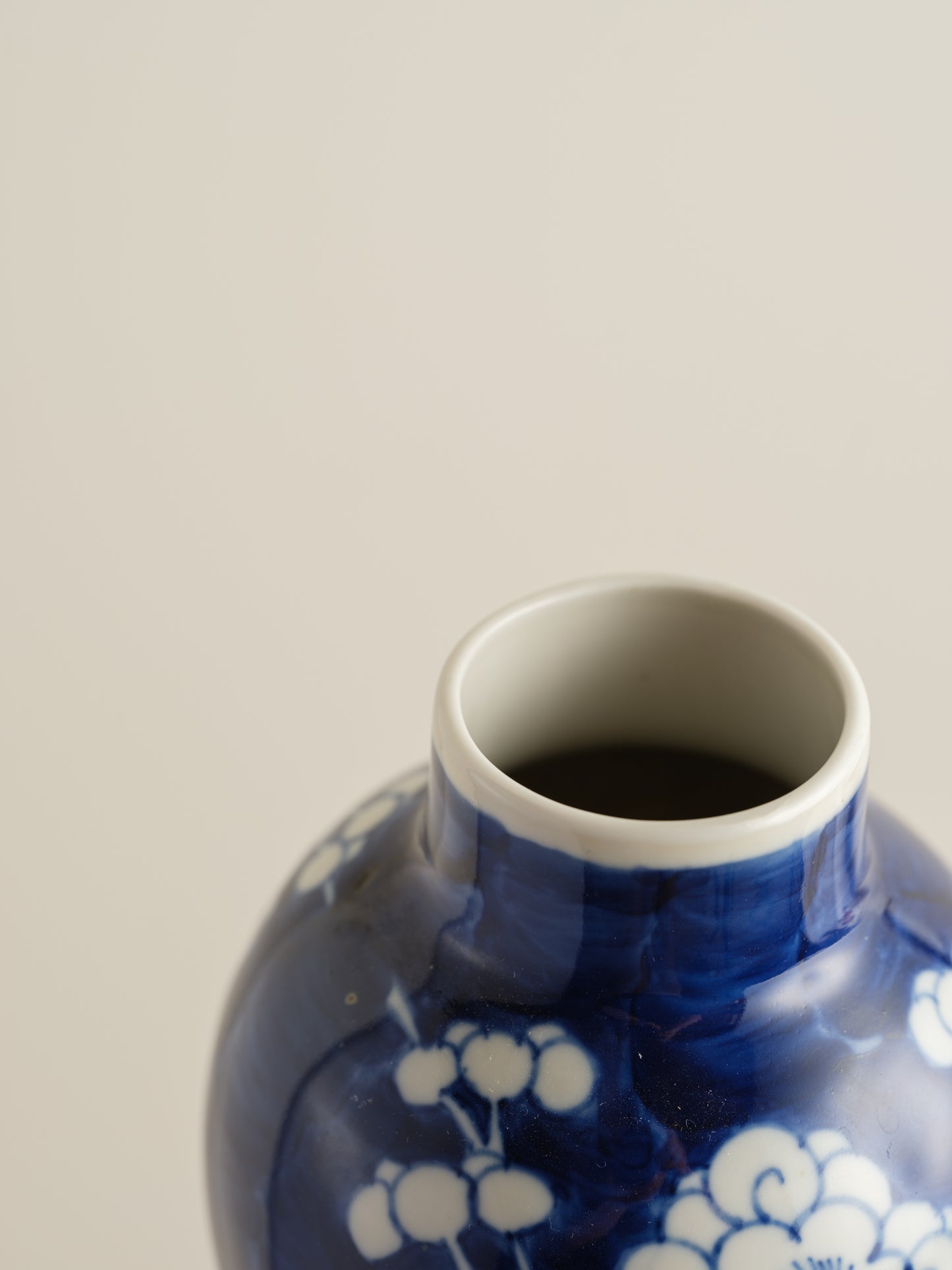Porcelain vase in deep indigo glaze featuring hand-painted white plum blossoms.