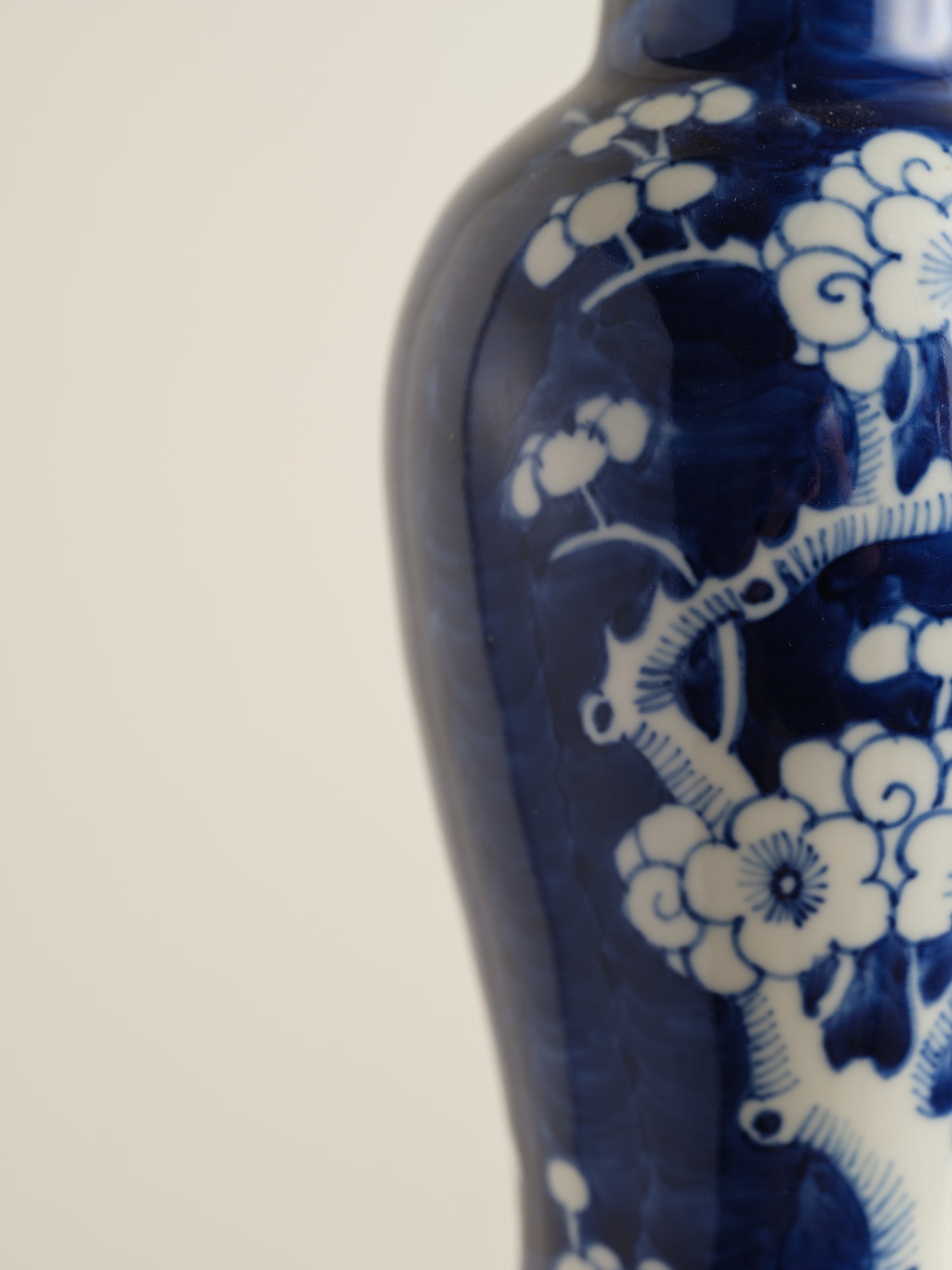 Porcelain vase in deep indigo glaze featuring hand-painted white plum blossoms.