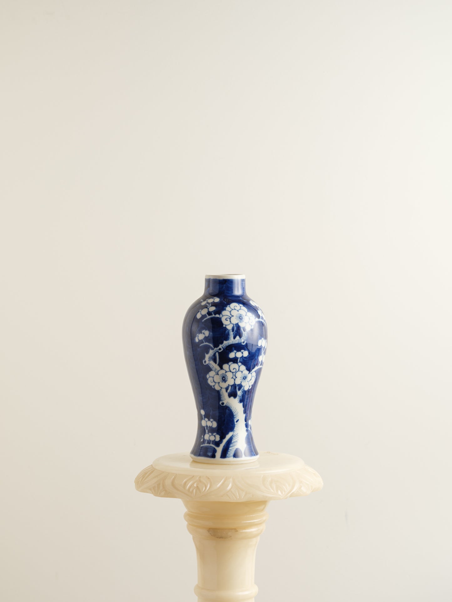 Porcelain vase in deep indigo glaze featuring hand-painted white plum blossoms.
