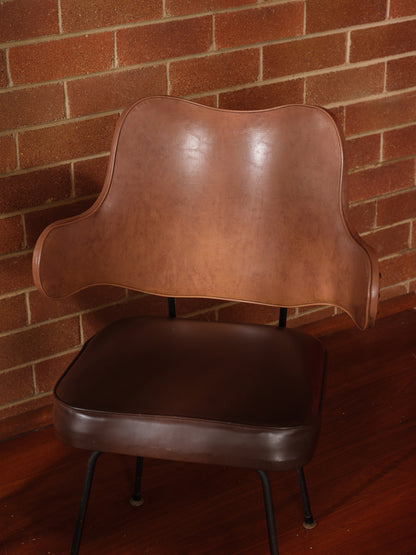Mid-Century brown leather dining chair with padded seat and sculpted backrest on slim metal legs