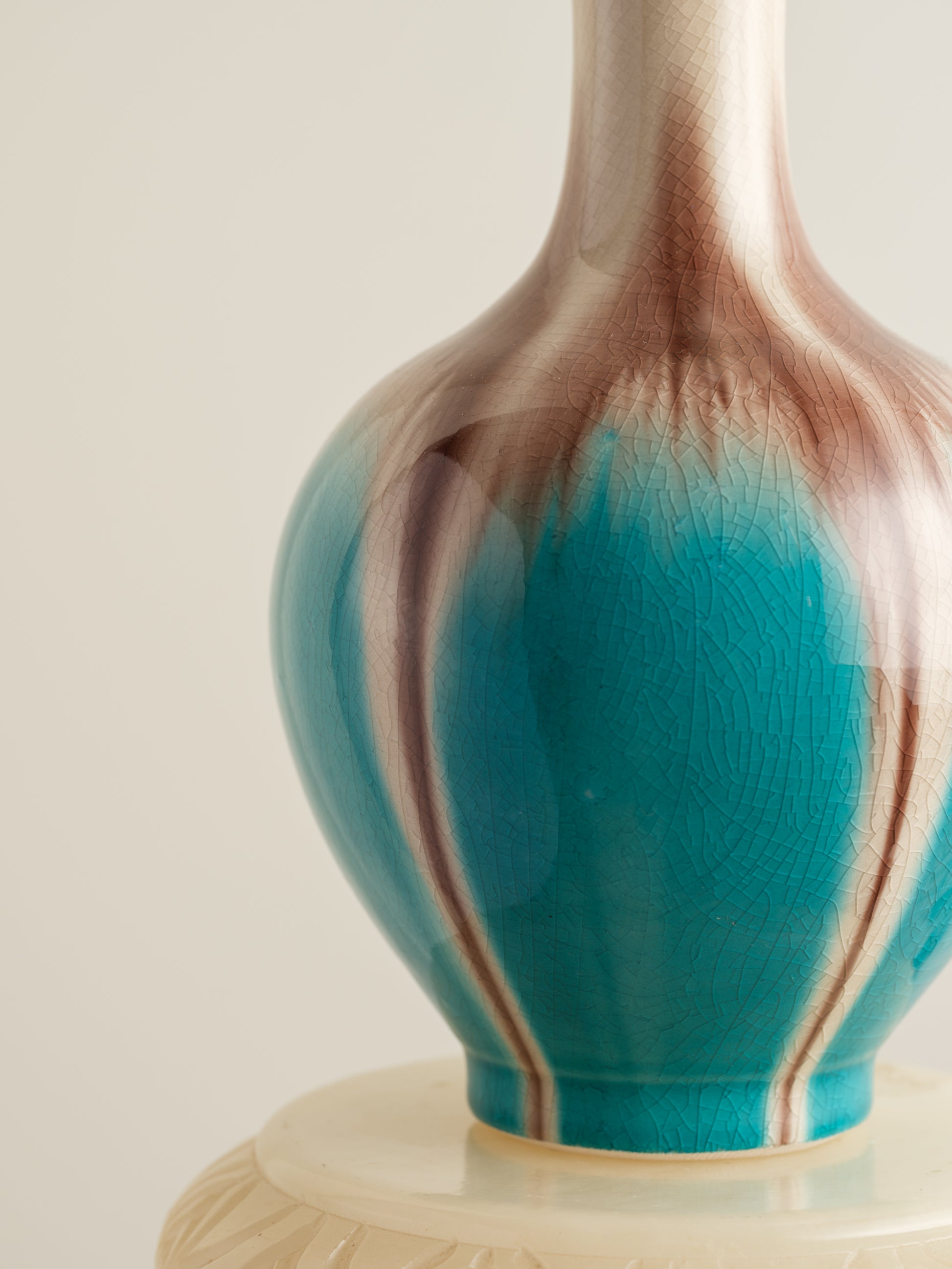 Ceramic vase with turquoise and beige drip glaze, featuring a flared neck and rounded form.