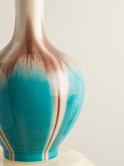 Ceramic vase with turquoise and beige drip glaze, featuring a flared neck and rounded form.