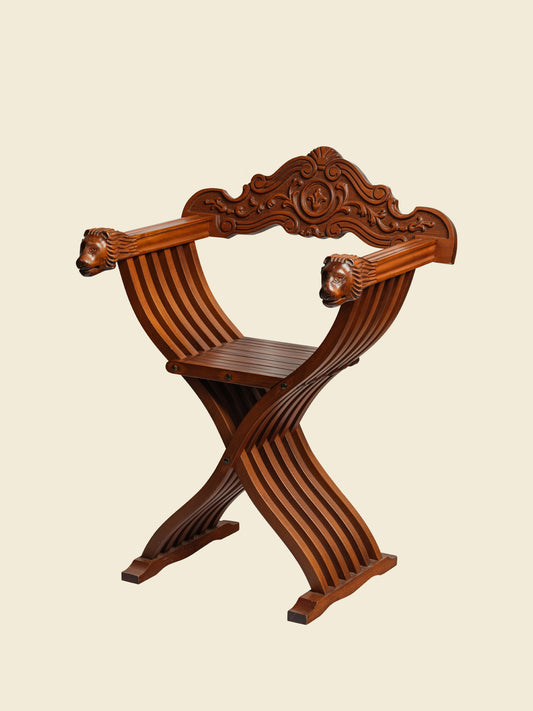 Antique wooden carved chair with lion head details in interior corner with birdcage background