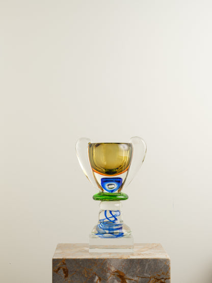 Multicoloured art glass vase with sculptural cup shape in yellow, green, blue and clear tones.