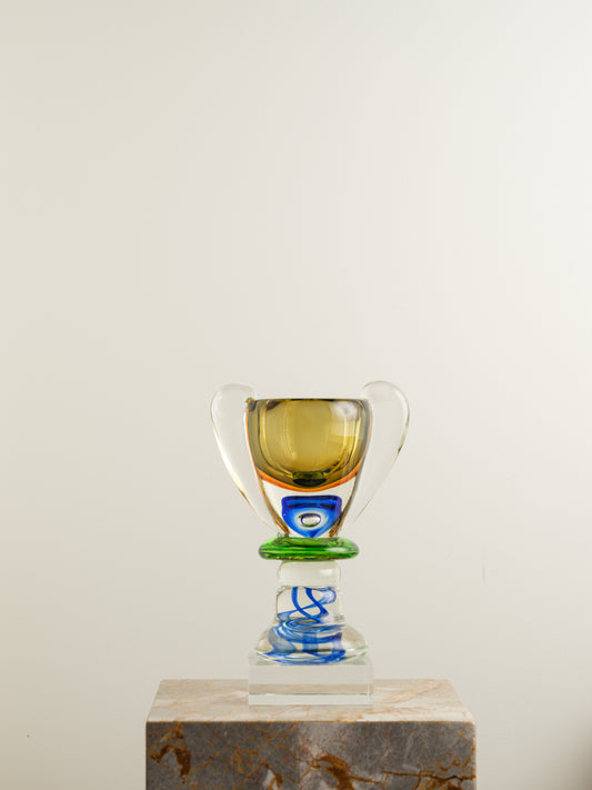 Multicoloured art glass vase with sculptural cup shape in yellow, green, blue and clear tones.