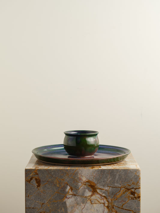 Hand-glazed ceramic bowl with matching charger in deep green and violet iridescent tones.